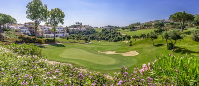 One of the greens at the La Cala Resort with beautiful colour flowers in the foreground and clear blue sky.
