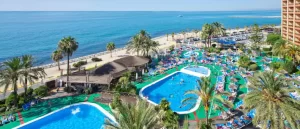 The Sunset Beach Club pool area from above with blue sea in the background.