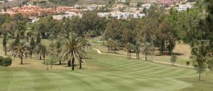 One of the fairways at El Paraiso Golf with well manicured grass and residential properties in the distance.