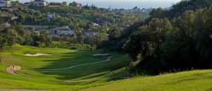 View of one of the holes at Marbella Golf and Country Club with a lush green fairway, the green to the distance and views of the Mediterranean Sea.