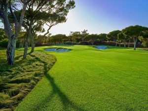 A manicured fairway at the Quinta do Lago North course with green in the distance surrounded by pine trees.