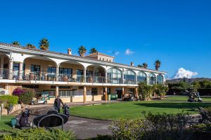 Clubhouse at the Bonalba course with putting green to the front, golf buggies and clear blue sky.