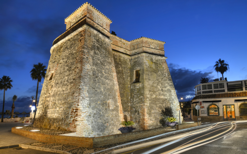 The famous Tower at La Cala de Mijas seafront lit up at night.