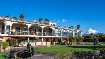 Clubhouse at the Bonalba course with putting green to the front, golf buggies and clear blue sky.