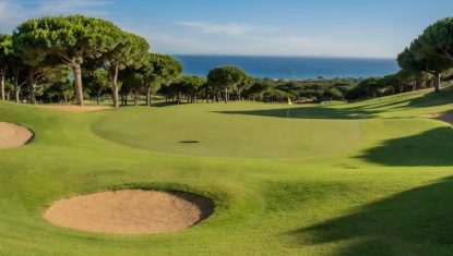 Scenic view of Cabopino Golf course with lush green fairways, sand bunkers, and ocean backdrop.