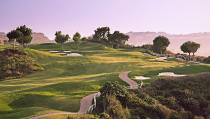 One of the holes at the La Cala America golf course with the sun shining on the fairway.