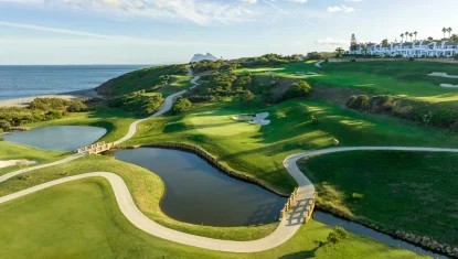 Golf course landscape with winding paths, water features, and a view of the ocean, representing La Hacienda links course.