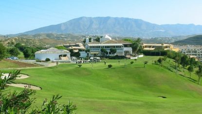A hole at Miraflores golf with the clubhouse in background and mountains further behind.