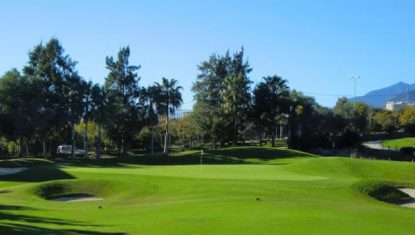 One of the greens at Santa Clara with trees behind and bunkers to the front right and left protecting the green.